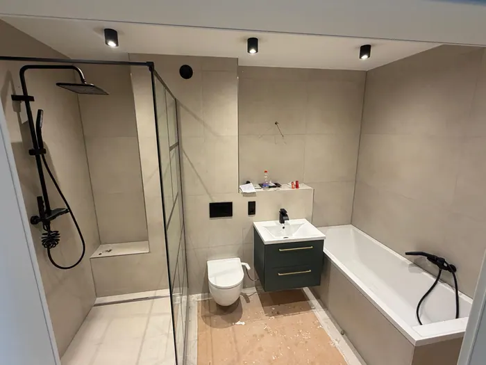 Fertig saniertes Bad mit Badewanne, Regendusche und schwarzen Armaturen
