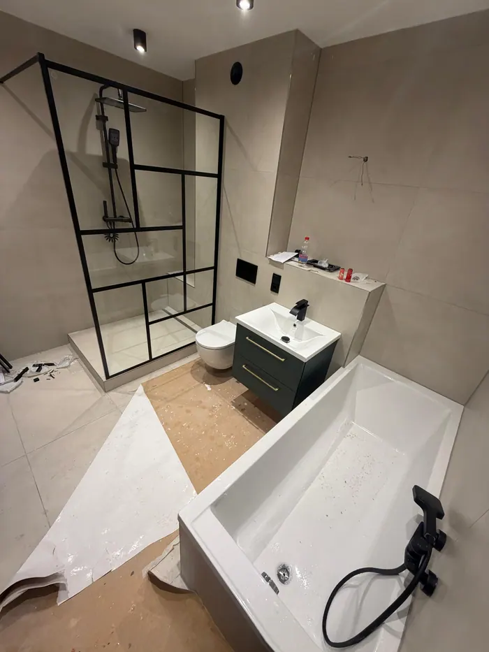 Bad mit schwarz gerahmter Duschabtrennung, Wanne und Waschtisch