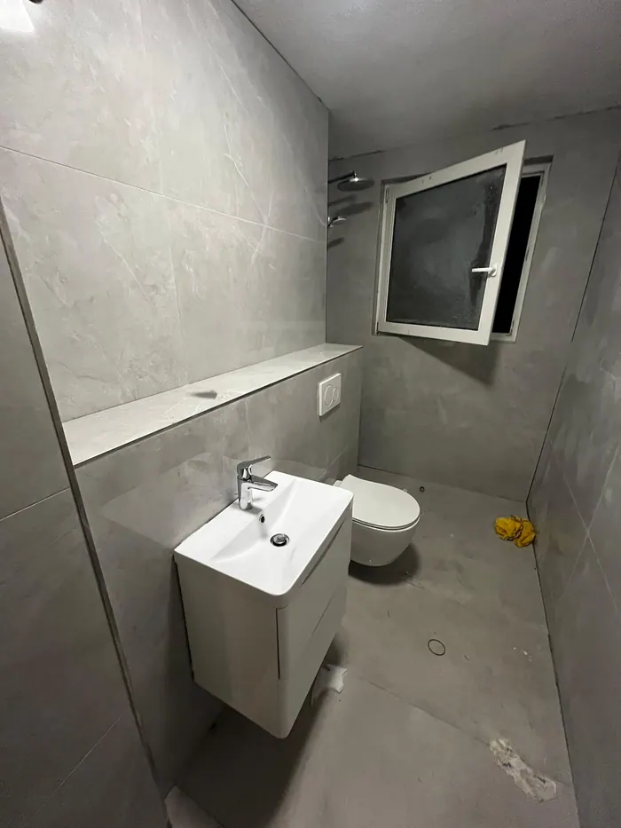 Gästebad in fugenloser Grauoptik mit Waschtisch und Wand-WC
