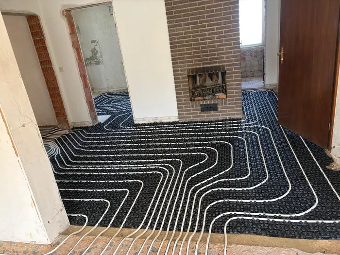 Fußbodenheizung im Altbau mit Noppenplatten vor einer Backsteinwand
